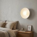 Biała minimalistyczna lampa na ścianę do salonów i sypialni.