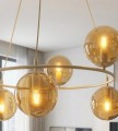 Lampa wisząca ring w kolorze beżowym o bursztynowych klosach.