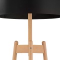 Lampa podłogowa z podstawą z jasnego drewna i czarnym dużym abażurem w kształcie walca.