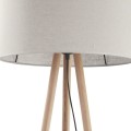Lampa stojąca trójnóg z drewnianą podstawą i beżowo - szarym dużym abażurem.