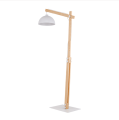 Regulowana drewniana lampa podłogowa z białym metalowym kloszem.