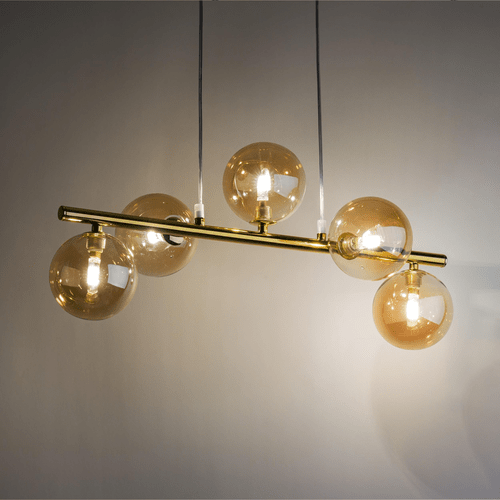 Złota lampa wisząca w poziomie z 5 kulkami w kolorze bursztynowym.