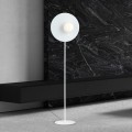 Biała designerska lampa podłogowa z białą kulka szklaną.