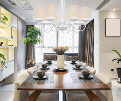 Biały żyrandol nad stół z kremowymi abażurami.